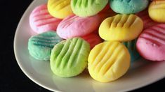 a white plate topped with different colored cookies