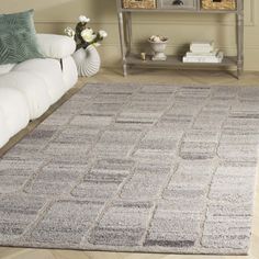 a living room with a white couch and gray rug