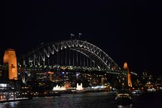 the sydney bridge lit up at night with lights on it's sides and buildings in the background