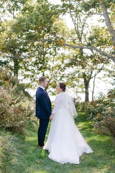 a bride and groom kissing in the woods