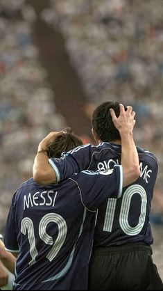 two soccer players hugging each other on the field