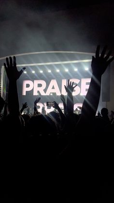 people are raising their hands in the air at a concert