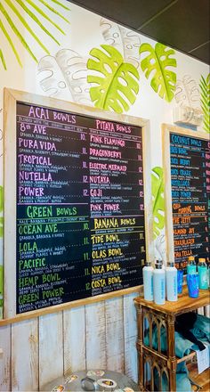 a menu board with drinks on it in front of a wall mounted sign that says, acai bowls