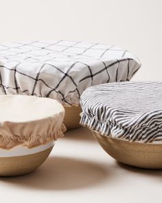 three bowls with covers on them sitting next to each other