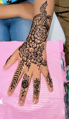 a woman's hand with henna tattoos on it