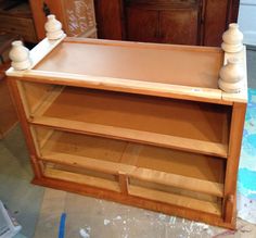 a wooden shelf with some white vases on it