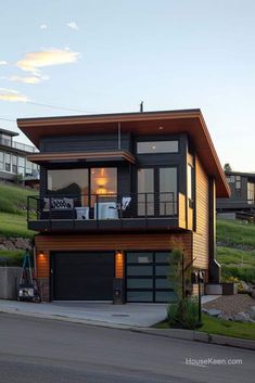 a two story house on the side of a hill with lots of windows and balconies