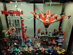 a display case filled with lots of legos and action figures in front of a building