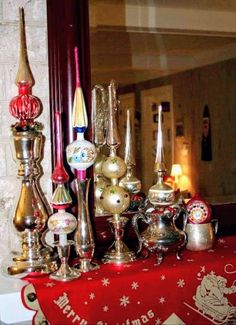 a table topped with lots of silver and gold items next to a mirror covered in christmas decorations