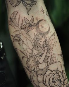 a tattoo on the arm of a woman with flowers and butterflies around her body,