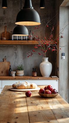 a wooden table topped with fruit next to a white vase filled with red berries on top of it