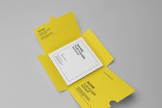 two yellow folders sitting on top of each other with paper attached to the sides