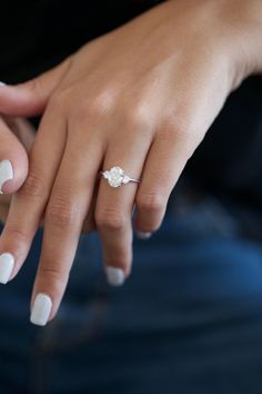 a woman's hand with white manicures and a ring on her finger