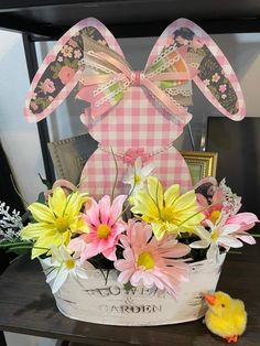 a basket filled with flowers sitting on top of a table next to a rubber duck