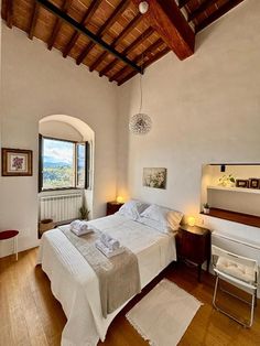 a bedroom with a large bed and wooden floors