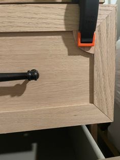 a close up of a drawer with an orange handle and black handles on the drawers