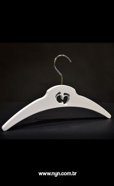 a white hanger with two black hearts on it's bottom and an oval hole in the middle