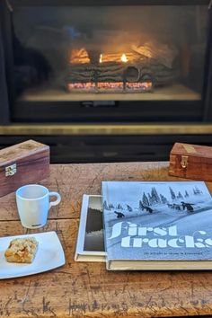 a table topped with a plate of food next to a fire place filled with logs