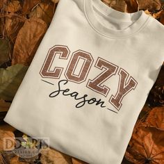 Get ready for 'Cozy Season' with our ultra-soft Gildan Unisex Heavy Blend™  Sweatshirt. A retro vintage vibe. Perfect for chilly days, it's your go-to for comfort and style. Whether relaxing at home or out enjoying the crisp air, this sweatshirt keeps you warm and fashionable all season long. ★Available in our unisex T-shirts and Sweatshirts. ★This shirt is made just for you and created with attention to detail. It takes us 2-3 days to make your order before shipping. Up to 4 days during peak ti Cozy Cotton T-shirt With Letter Print, Cozy White Graphic Print T-shirt, Cozy White Tops With Letter Print, White Letter Print Cozy Top, Cozy White Cotton T-shirt, Cozy Crew Neck T-shirt With Letter Print, Cozy Letter Print T-shirt For Loungewear, Cozy T-shirt With Letter Print For Loungewear, Cozy Text Print Tops For Winter