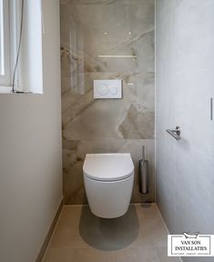 a white toilet sitting inside of a bathroom next to a wall mounted air conditioner