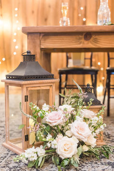 a bouquet of flowers sitting on top of a table next to a light fixture with lights in the background