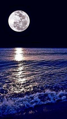 the full moon shines brightly over the ocean as it reflects in the water's surface