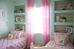 a bedroom with two twin beds and pink curtains