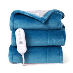 an electric heated blanket is sitting on top of two folded blankets, one blue and the other white