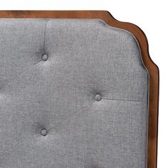 an upholstered headboard with buttons and wood trimmings on the sides