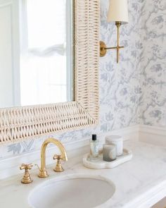 a white sink sitting under a bathroom mirror next to a wall mounted faucet