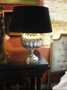 a lamp on a table next to a bed