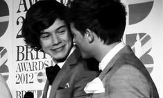 black and white photograph of two men in suits at an awards ceremony, one is holding his hand on the other's shoulder