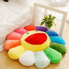 a rainbow colored pillow sitting on top of a bed next to a potted plant