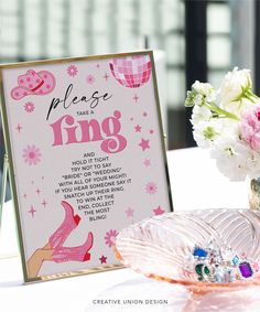 a table with a sign and flowers on it that says please take the ring, hold it tight