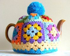 a crocheted tea pot with a wooden handle