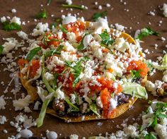 a tortilla topped with tomatoes, cheese and lettuce