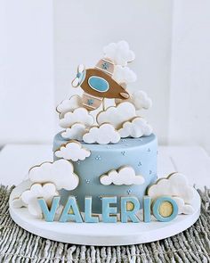 there is a cake with clouds and a plane on top that says valerio in blue