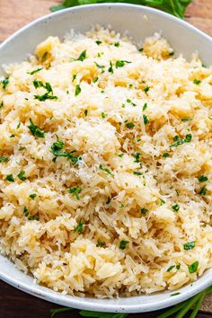 a white bowl filled with rice on top of a wooden table