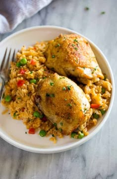 chicken and rice on a plate with a fork