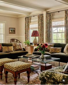 a living room filled with lots of furniture and flowers on top of a coffee table