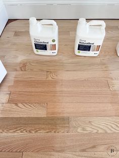 three gallon jugs of wood floor cleaner sitting on top of a hard wood floor