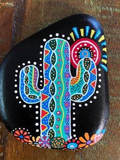 a painted rock with a cactus on it