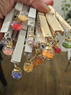 a person holding a bunch of key chains with different colored beads hanging from it's ends