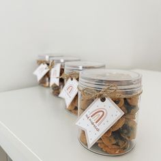 three jars filled with cookies sitting on top of a white counter next to each other