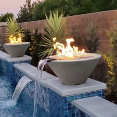 an outdoor fire pit in the middle of a swimming pool with water running from it