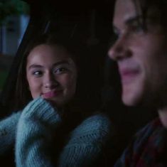 two people sitting in the back seat of a car at night