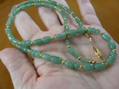 "(Internal #V507-1)  You are bidding on a beautiful, handmade, 23\" long green aventurine necklace with barrel 8x5 and 7x5 mm; donut shaped 6x4 mm and 5x3 mm; gold alloy safety clasp closure. This is the exact item you will receive. WE SHIP WORLDWIDE!  Other accepted payment: Credit card (Mastercard/Visa/Discover) inquire for details." Spiritual Gold Jade Beaded Necklaces, Spiritual Gold Jade Beaded Necklace, Gold Jade Beaded Necklaces With Gemstone Beads, Gold Jade Beaded Necklaces With Gemstones, Gold Jade Gemstone Beaded Necklaces, Hand-strung Gold Emerald Necklace Gift, Gold Jade Beaded Necklaces With Round Beads, Gold Jade Round Beaded Necklaces, Green Aventurine Necklace