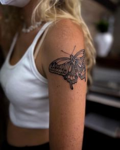 a woman with a butterfly tattoo on her arm