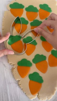 someone cutting out carrots on top of a cookie