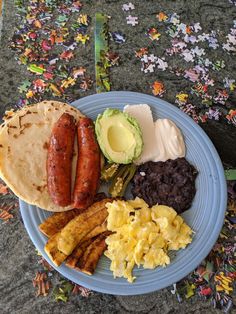 a blue plate topped with breakfast foods on top of a table